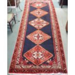 A blue ground Karajeh runner with five central lozenges, 310cm x 118cm Condition Report: Available