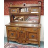 An oak Arts and Crafts sideboard with pierced top rail, mirror and two doors with main mirror on a