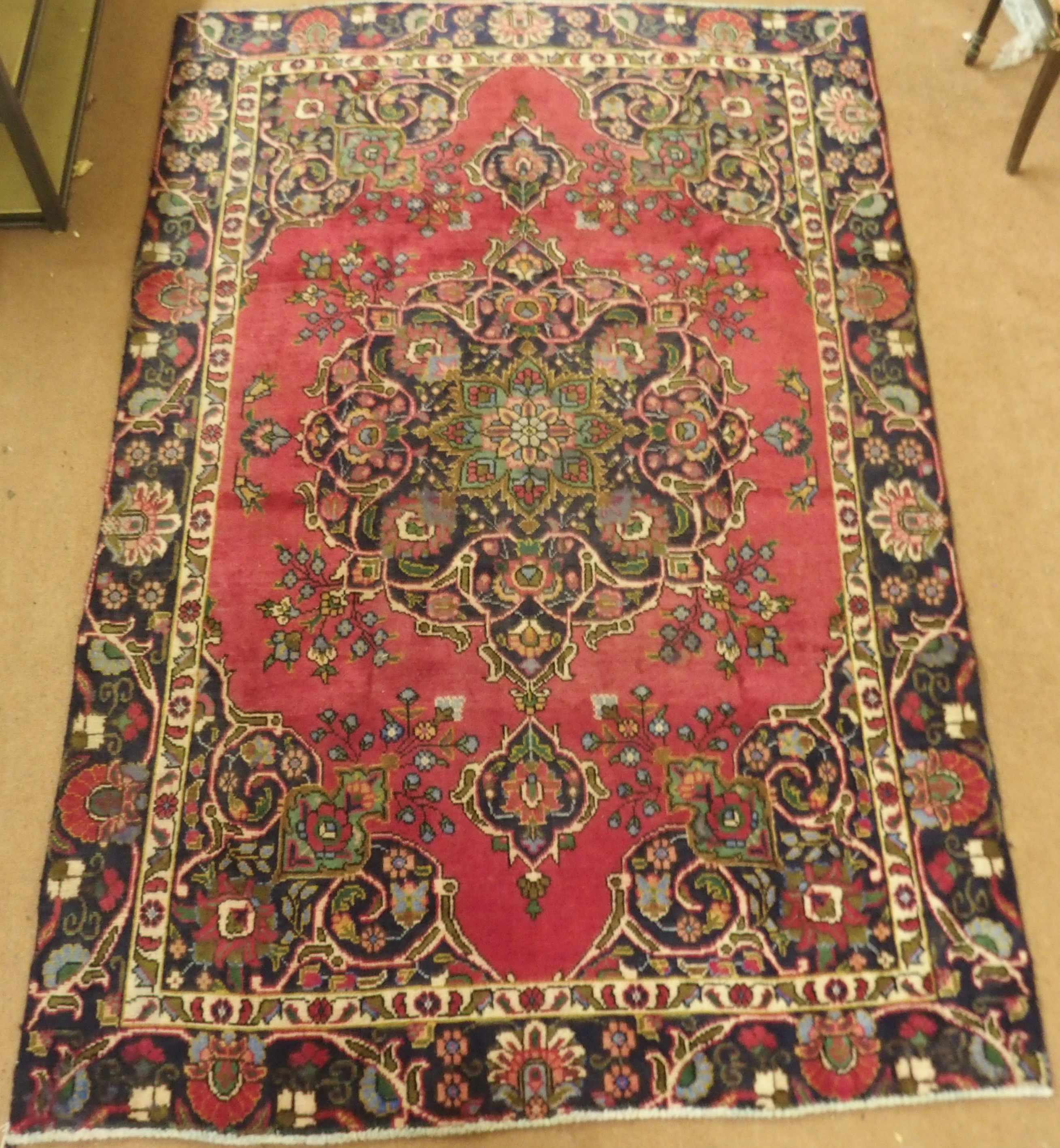 A red ground vintage Tabriz rug with floral medallion design, 282cm x 186cm Condition Report: