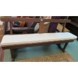 An oak bench with seat pad, 77cm high x 152cm wide Condition Report: Available upon request