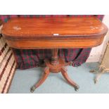 A Victorian mahogany inlaid fold over tea table on pedestal base with sabre legs and hairy paw brass