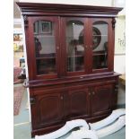 A mahogany bookcase with three glazed doors over a base with three drawers over three doors, 210cm