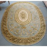 A green ground oval wool rug with floral central medallion, 243cm x 168cm, Condition Report: