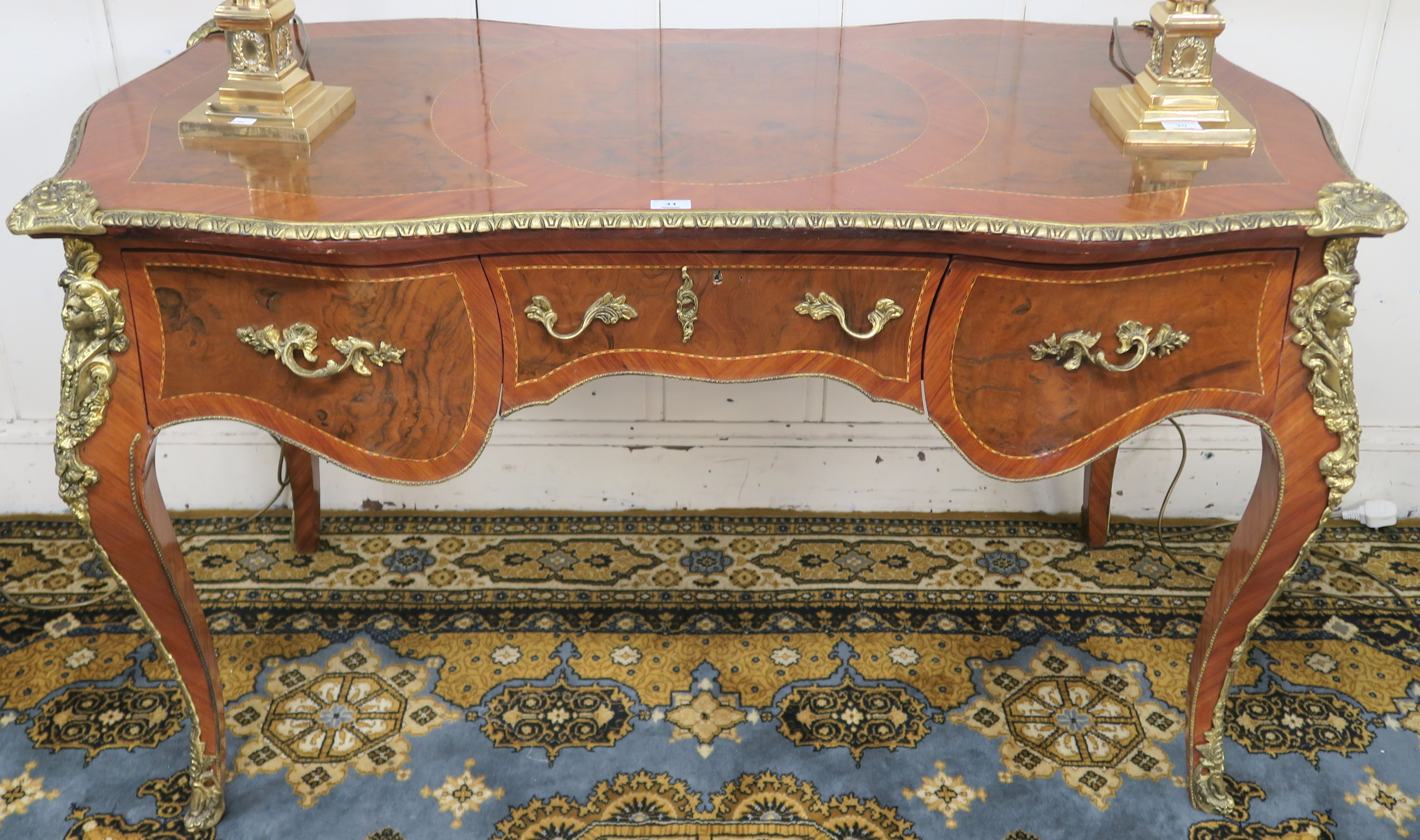 A Louis XV style writing desk with central drawer flanked by a pair of drawers with gilt metal