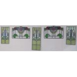 A leaded and stained glass panel, 56cm x 23cm with two matching panels, 43cm x 22cm and a pair of