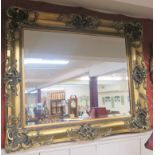 A modern gilt ornate wall mirror, 110cm x 130cm Condition Report: Available upon request