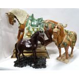 A large Tang style horse on wooden base 32cm long, another smaller and a carved wooden horse with