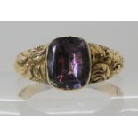 An early Victorian ring with foiled back amethyst and floral embosses shoulders, finger size