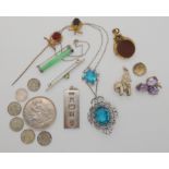 A Chinese green hardstone white metal mounted brooch, a silver ingot pendant, 1897 silver crown coin