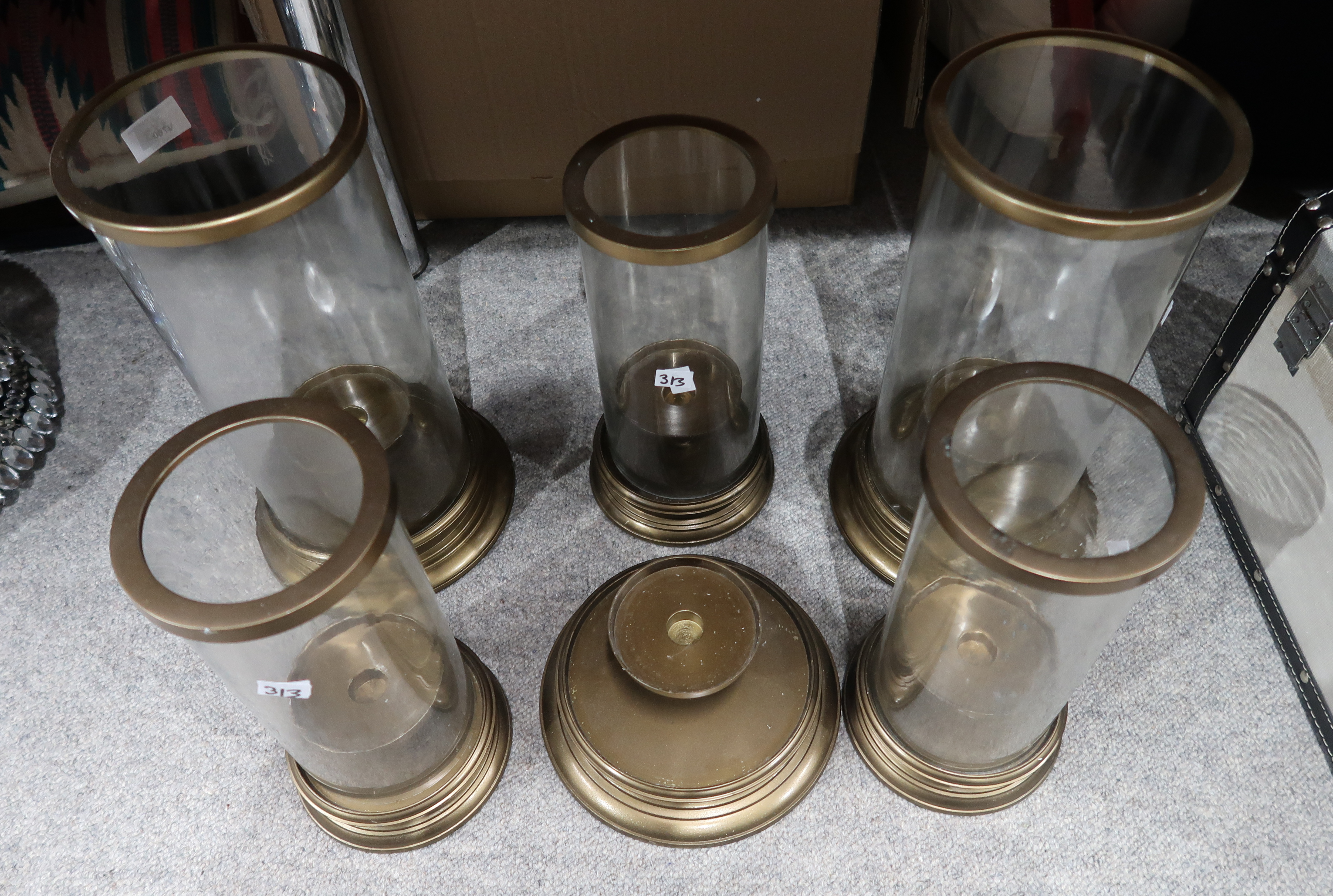 Two large glass hurricane lamps, an extra base and three smaller examples Condition Report: Not