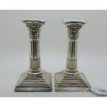 A pair of silver candlesticks, Sheffield 1911, with removable drip pans on Corinthian columns on