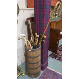 An oak coopered stick stand with various sticks and umbrellas Condition Report: Available upon