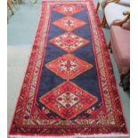 A blue ground Karajeh runner with five central lozenges, 310cm x 118cm Condition Report: Available