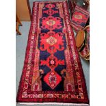 A Northern Iranian runner with a rich red medallion design, 300cm x 110cm Condition Report: