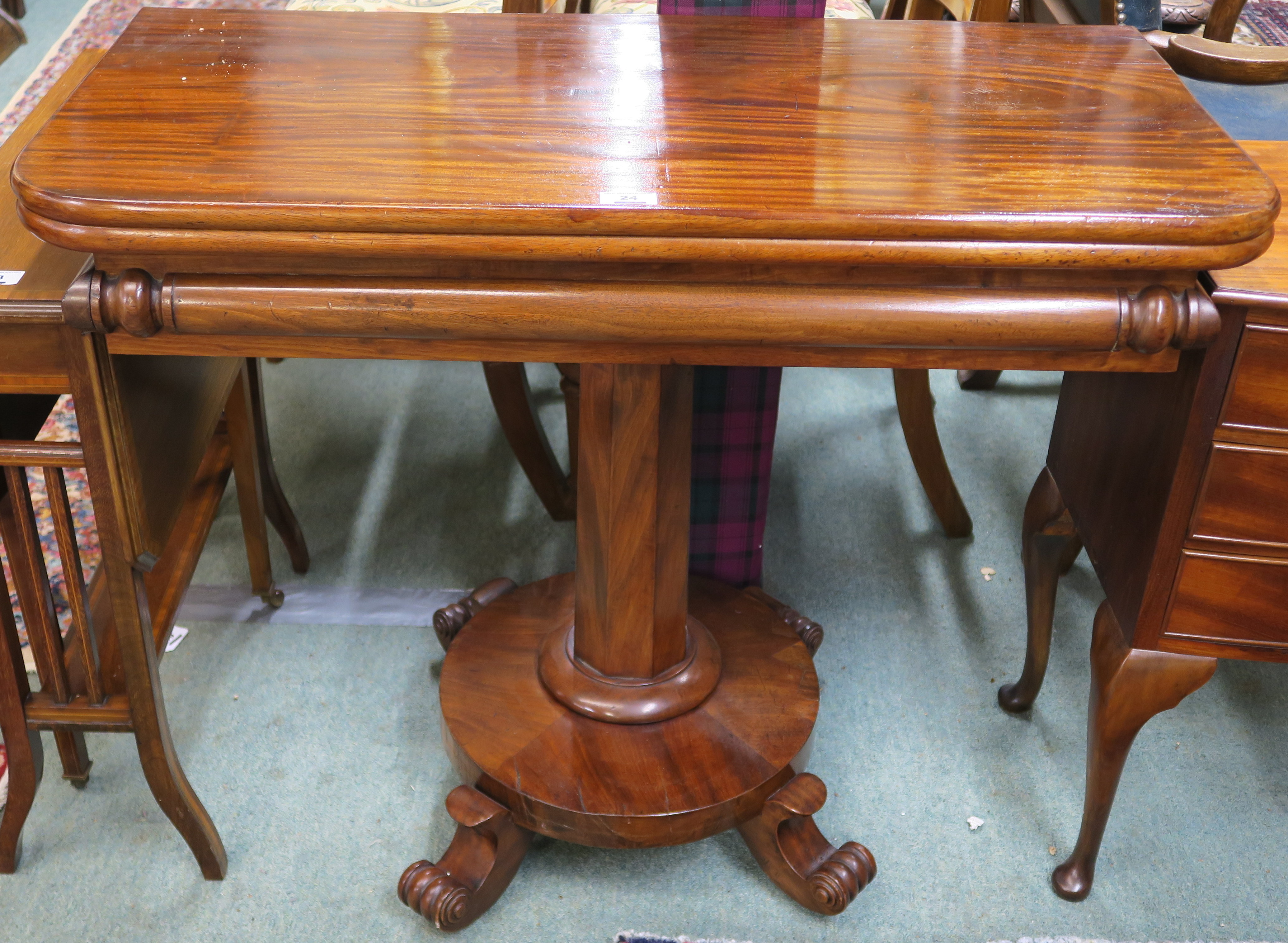 A Victorian mahogany fold over tea table on a pedestal base with four scroll feet, 74cm high x