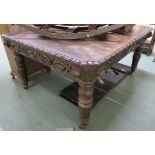 A Victorian oak wind out extending dining table with carved frieze and two leaves on turned legs,