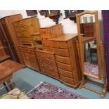 A pine bedroom suite comprising double wardrobe, two four drawer chests, cabinet, narrow six