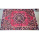 A red ground vintage Tabriz rug with floral medallion design, 282cm x 186cm Condition Report: