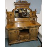 An oak sideboard with mirror back with carved flower panels on a base with two frieze drawers