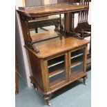 A Victorian walnut music cabinet with brass gallery on inlaid top, mirror back on a base with two