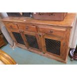 A Modern hardwood sideboard with three drawers over three doors with metal grill front, 90cm high