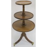 A three tier mahogany dumb waiter on tripod base with brass castors 101cm high Condition Report: