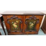 A two door cabinet with floral painted panels within carved frames, 86cm high x 129cm wide x 45cm