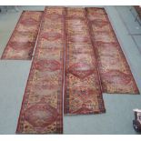 Four red ground carpet runners, 428cm, 235cm, 396cm, 356cm x 70cm wide (4) Provenance: The Late Dr