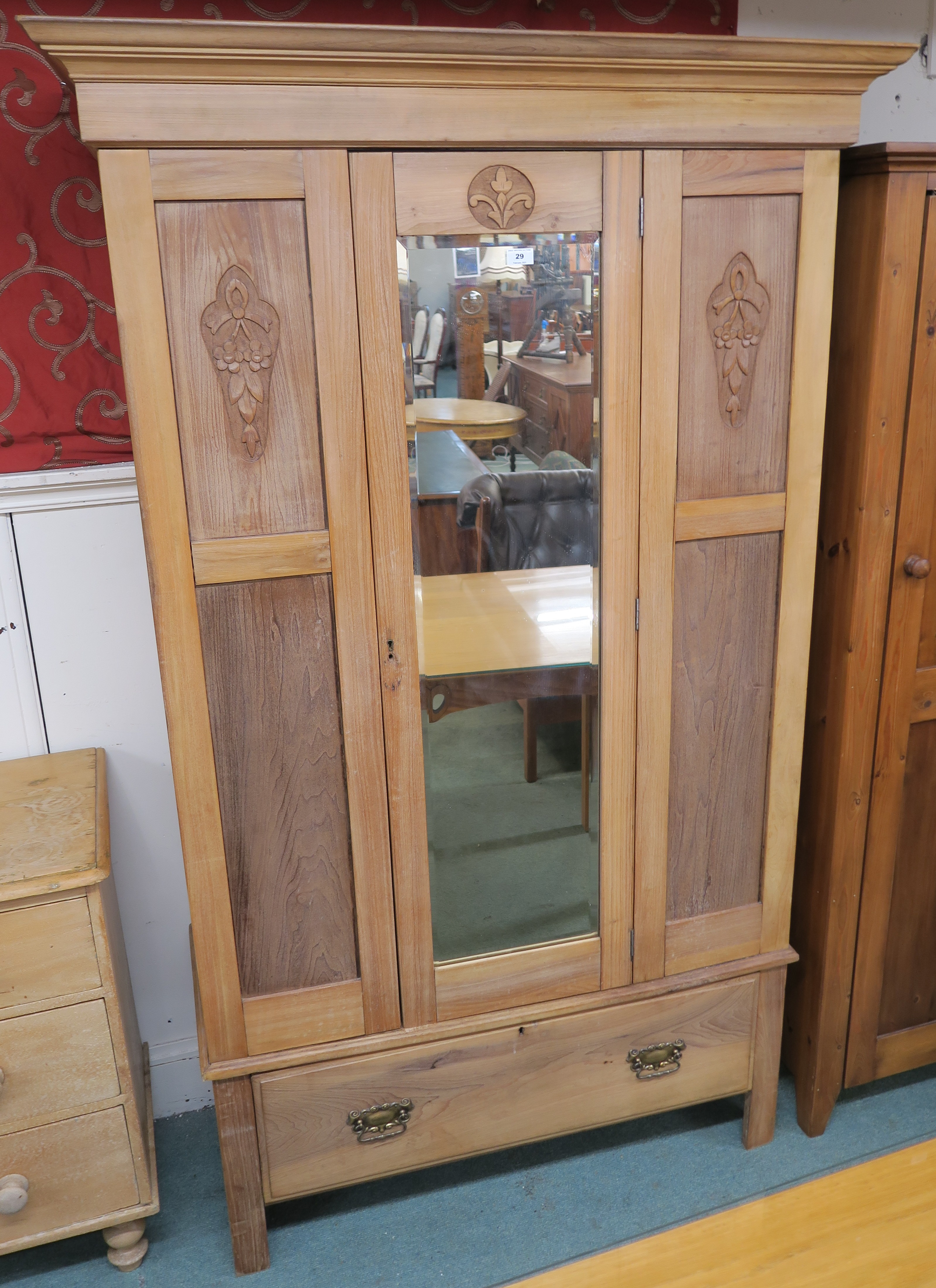 A wardrobe with carved panels and a single mirrored door over single drawer, 196cm high x 118cm wide