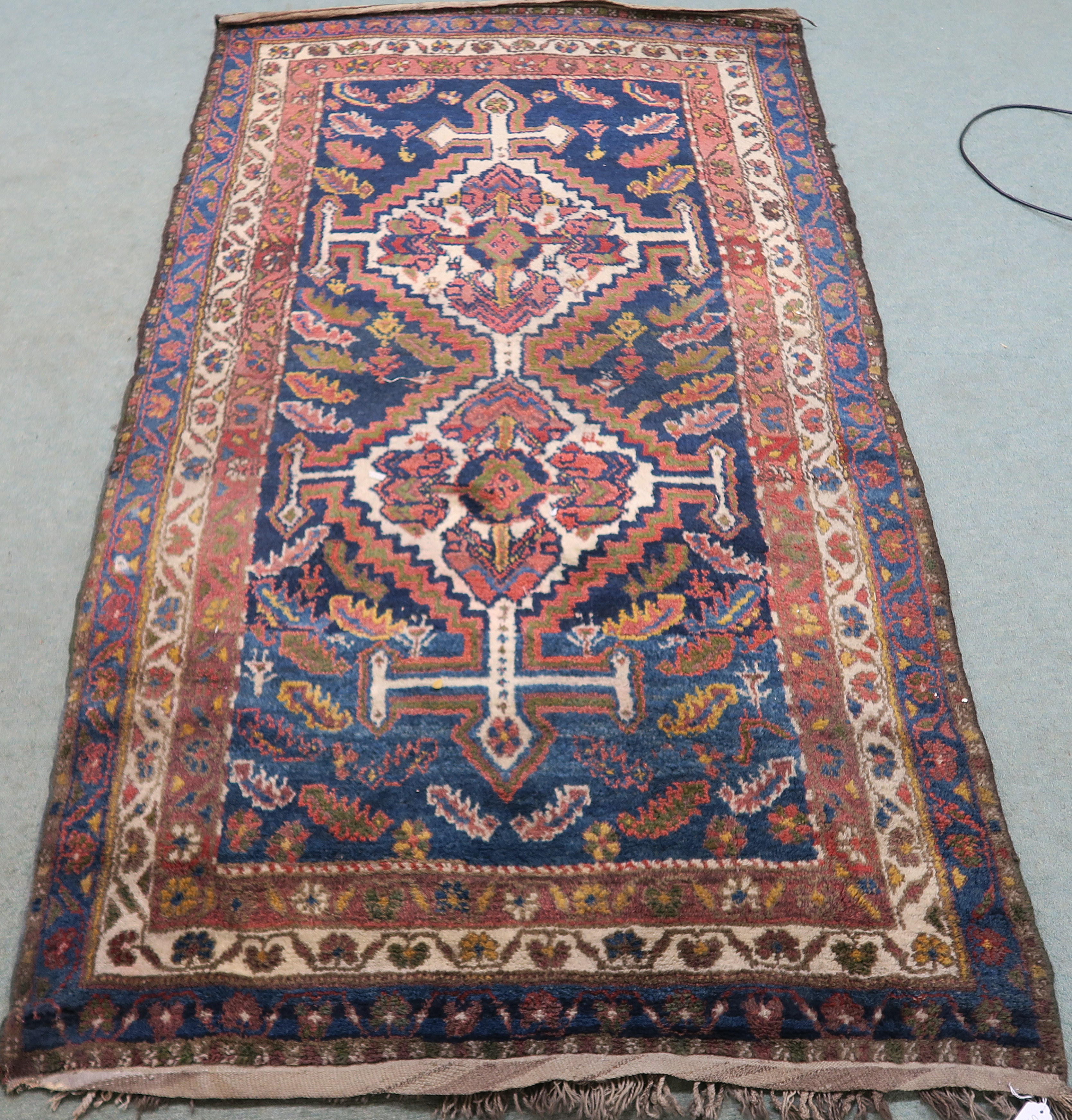 A blue ground Eastern rug with stylised birds and animals with two central medallions, 225cm x 123cm