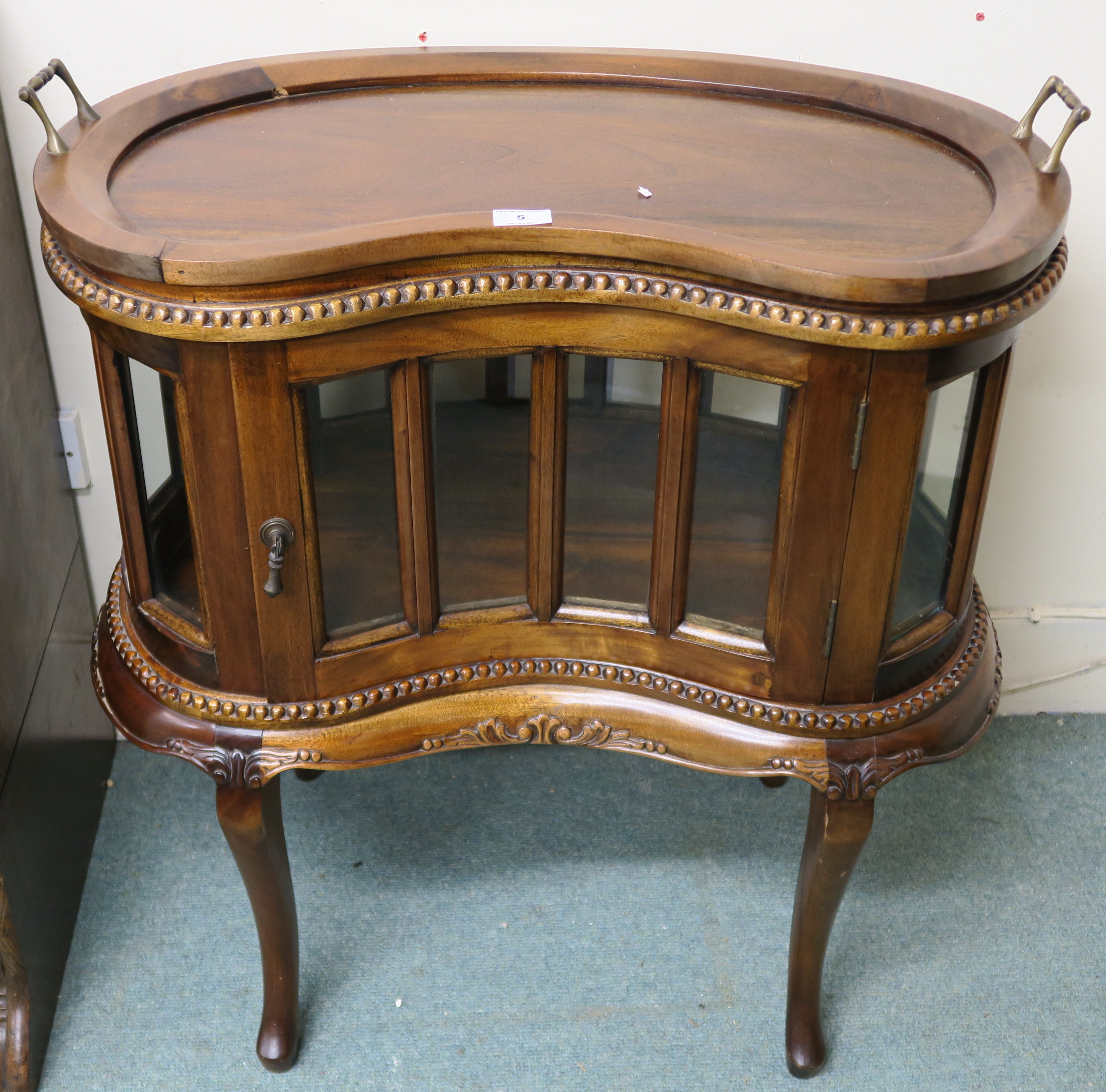 A reproduction hardwood kidney shaped drinks cabinet with serving tray, 82cm high x 75cm wide x 45cm