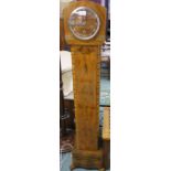 An Art Deco 1930's figured walnut grandmother clock. The Art Deco case having a silvered chapter