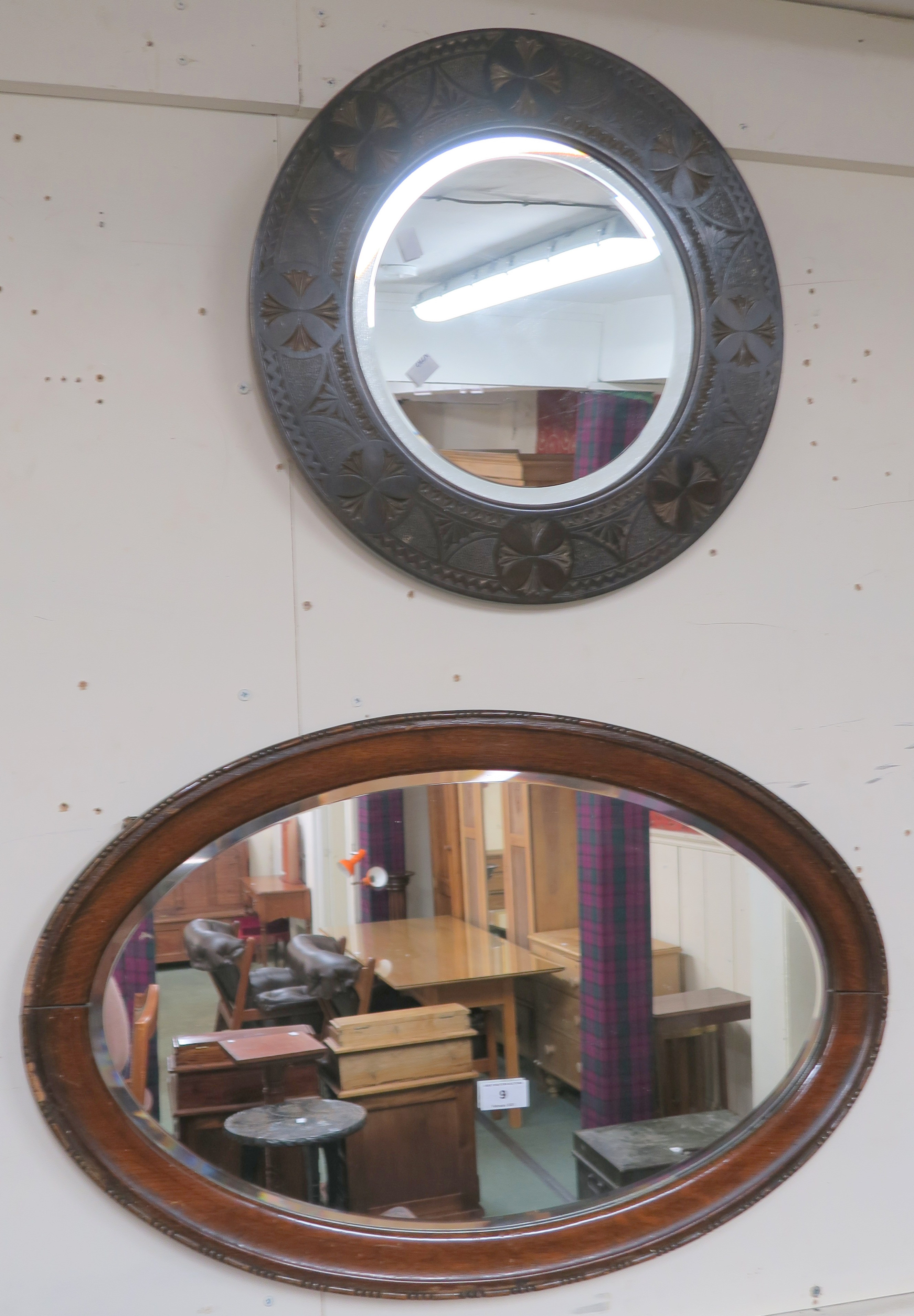 A carved oak circular wall mirror 46cm diameter and an oval wall mirror (2) Condition Report: