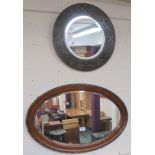 A carved oak circular wall mirror 46cm diameter and an oval wall mirror (2) Condition Report:
