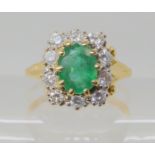 An 18ct gold emerald and diamond cluster ring, set with estimated approx 0.40cts of brilliant cut