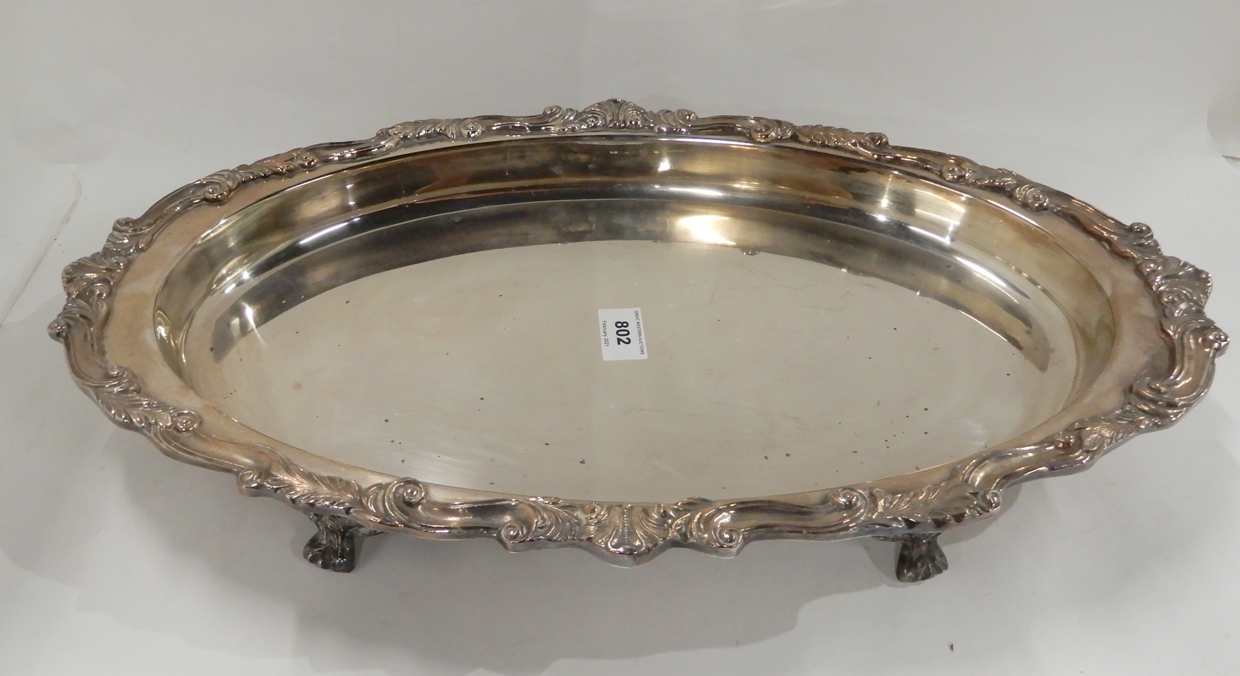 A silver plated serving dish, oval shaped on four scrolling feet, 50cm x 32cm Condition Report: