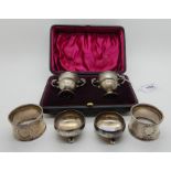 A lot comprising a cased pair of silver condiments, London 1898, a pair of napkin rings and a pair