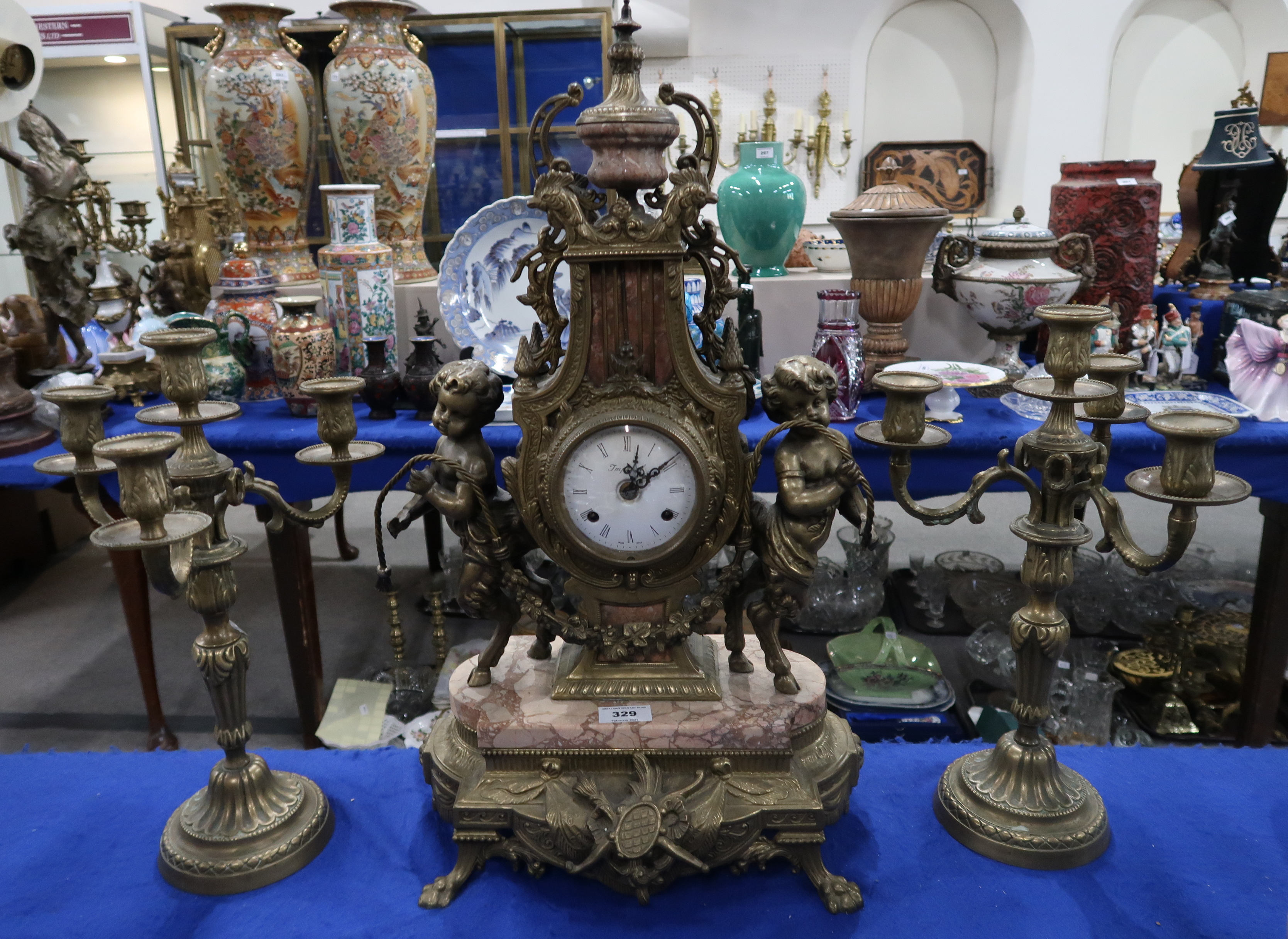 An Italian Imperial clock garniture, the dial with Roman numerals flanked either side by fauns, upon