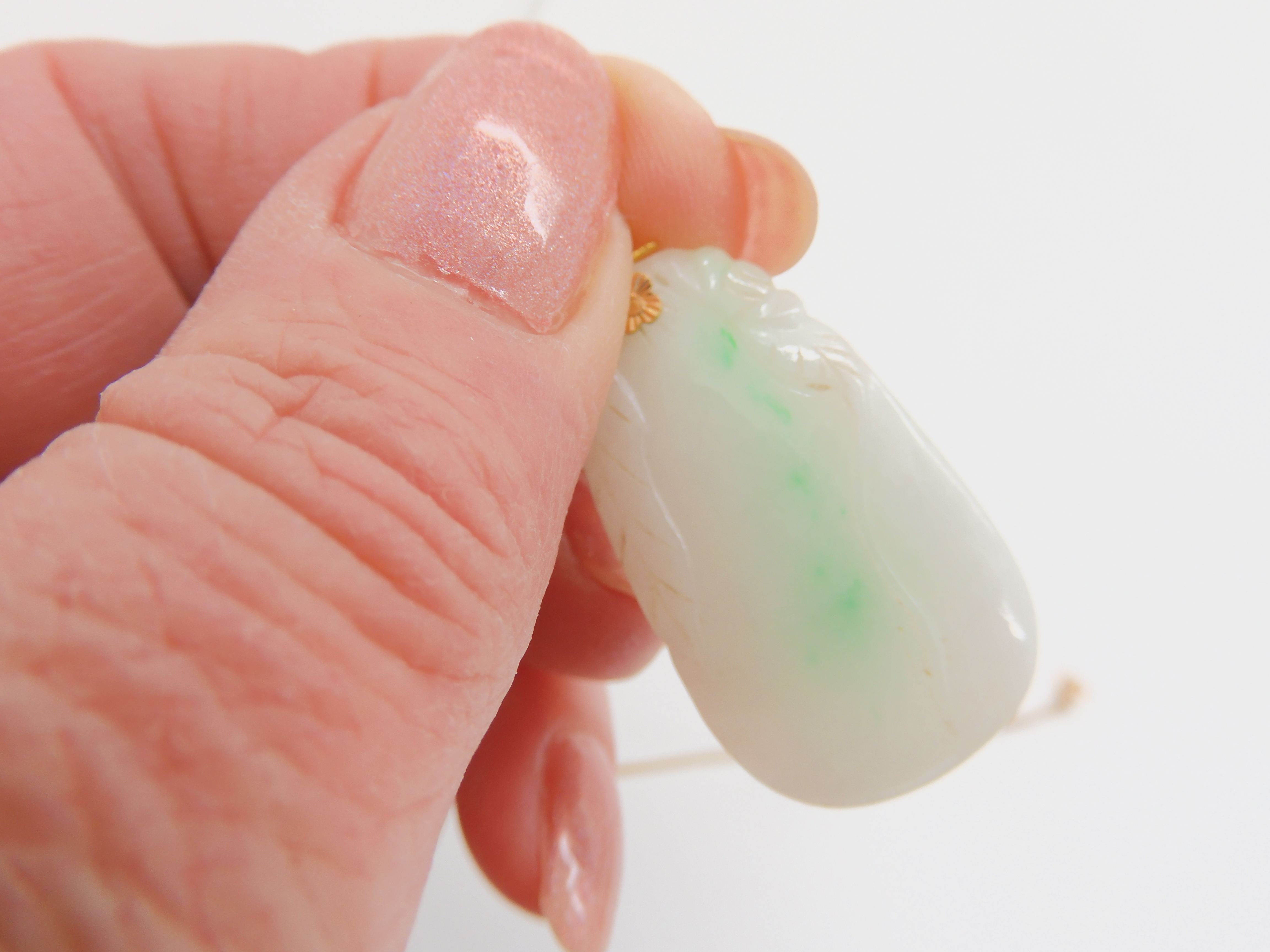 A white Chinese hardstone pendant carved with leaves with splashes of green, mounted in bright - Image 3 of 5