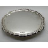 A silver card tray, Sheffield 1936, circular with scalloped rim on three scrolling feet, 25.5cm