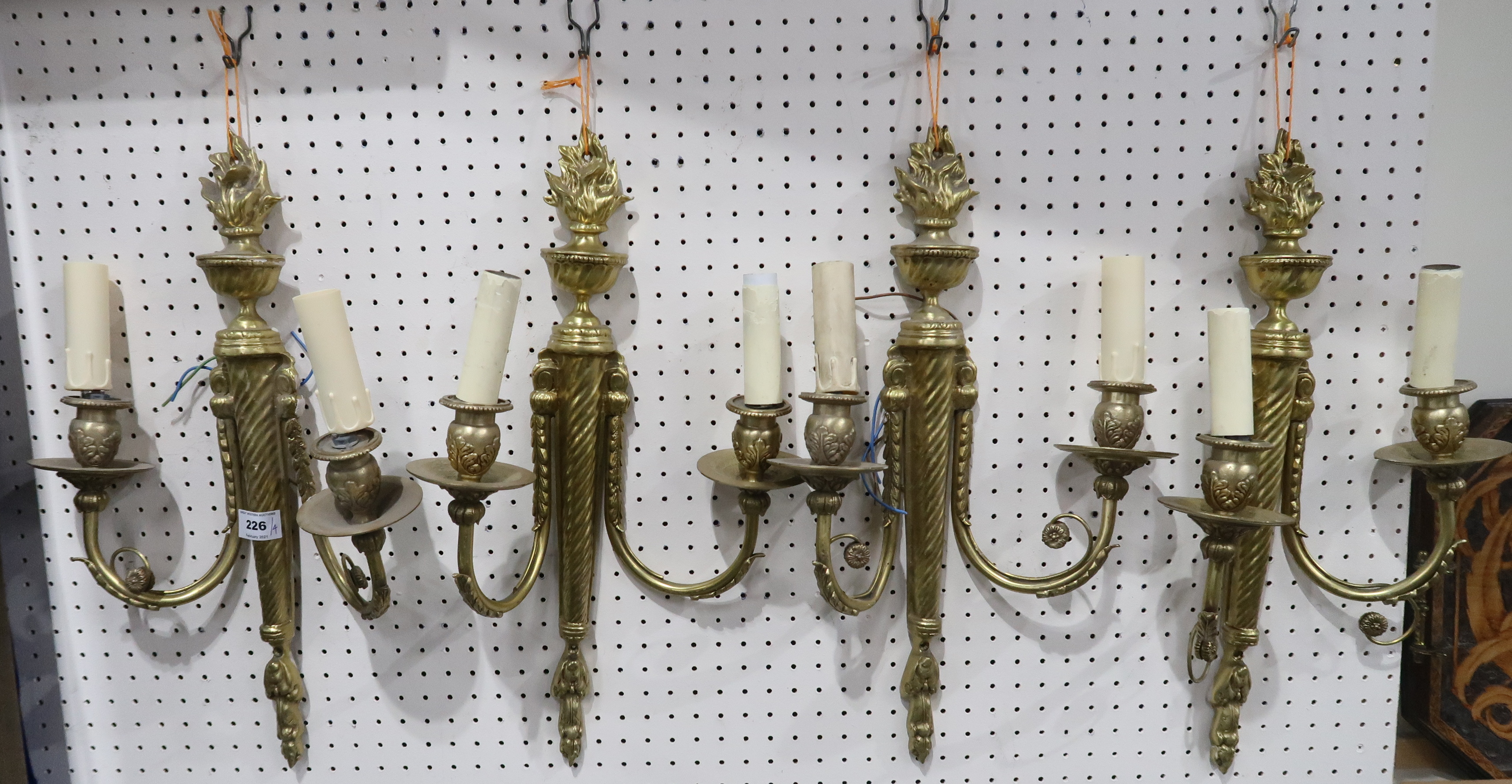 A set of four French gilt metal wall sconces with flame finials, 48cm high Condition Report: Not