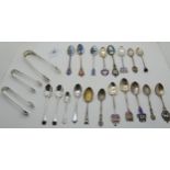 A lot comprising a pair of silver sugar tongs, two more pairs and a collection of mainly silver