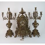 A LARGE GILT METAL CLOCK GARNITURE - The clock with Roman numerals and central mask decoration, the