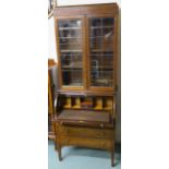 An Edwardian mahogany inlaid bookcase with lower cylinder bureau with three graduating drawers on