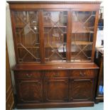 A reproduction mahogany bookcase with three glazed doors over a base with three drawers and three