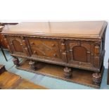 A carved oak sideboard with two drawers flanked by two doors on carved baluster supports, 93cm