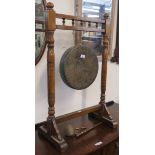 A Burmese brass gong on oak stand, 88cm high x 56cm wide x 33cm deep with striker (broken)