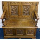 A carved oak monks bench, 98cm high x 107cm wide x 54cm deep Condition Report: Available upon