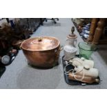 A large copper storage bucket upon claw feet, a porcelain lamp with pierced body, a green glass