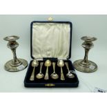 A lot comprising a pair of silver candlesticks, Birmingham 1906, weighted, 10cm high & a cased set